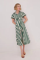 Woman wearing a green and white striped dress against a white background
