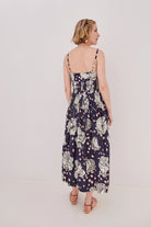 Woman wearing a floral dress on a plain background