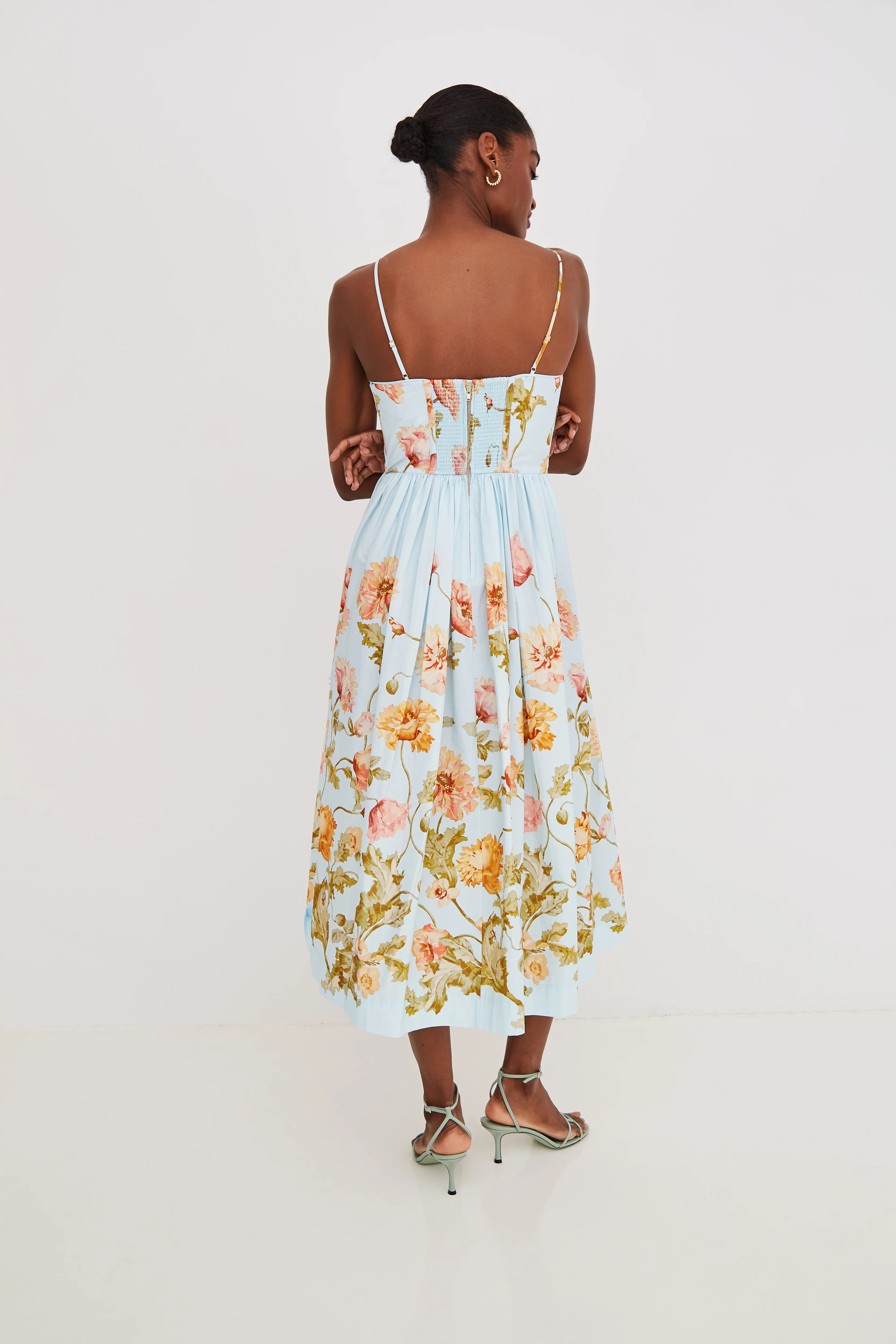 Woman wearing a floral dress on a plain background