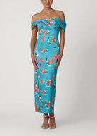 Woman wearing a blue floral off-shoulder dress on a white background