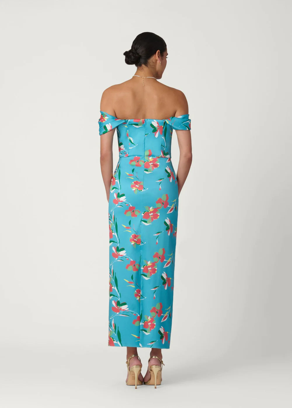 Woman wearing a blue floral off-shoulder dress on a white background