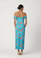 Woman wearing a blue floral off-shoulder dress on a white background