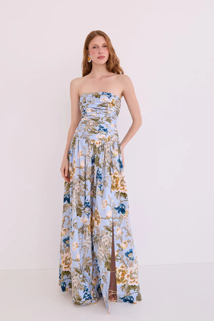 Woman wearing a strapless floral dress on a white background