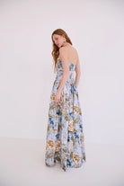 Woman wearing a floral strapless dress on a white background