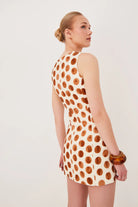 Woman wearing a polka dot dress on a plain background