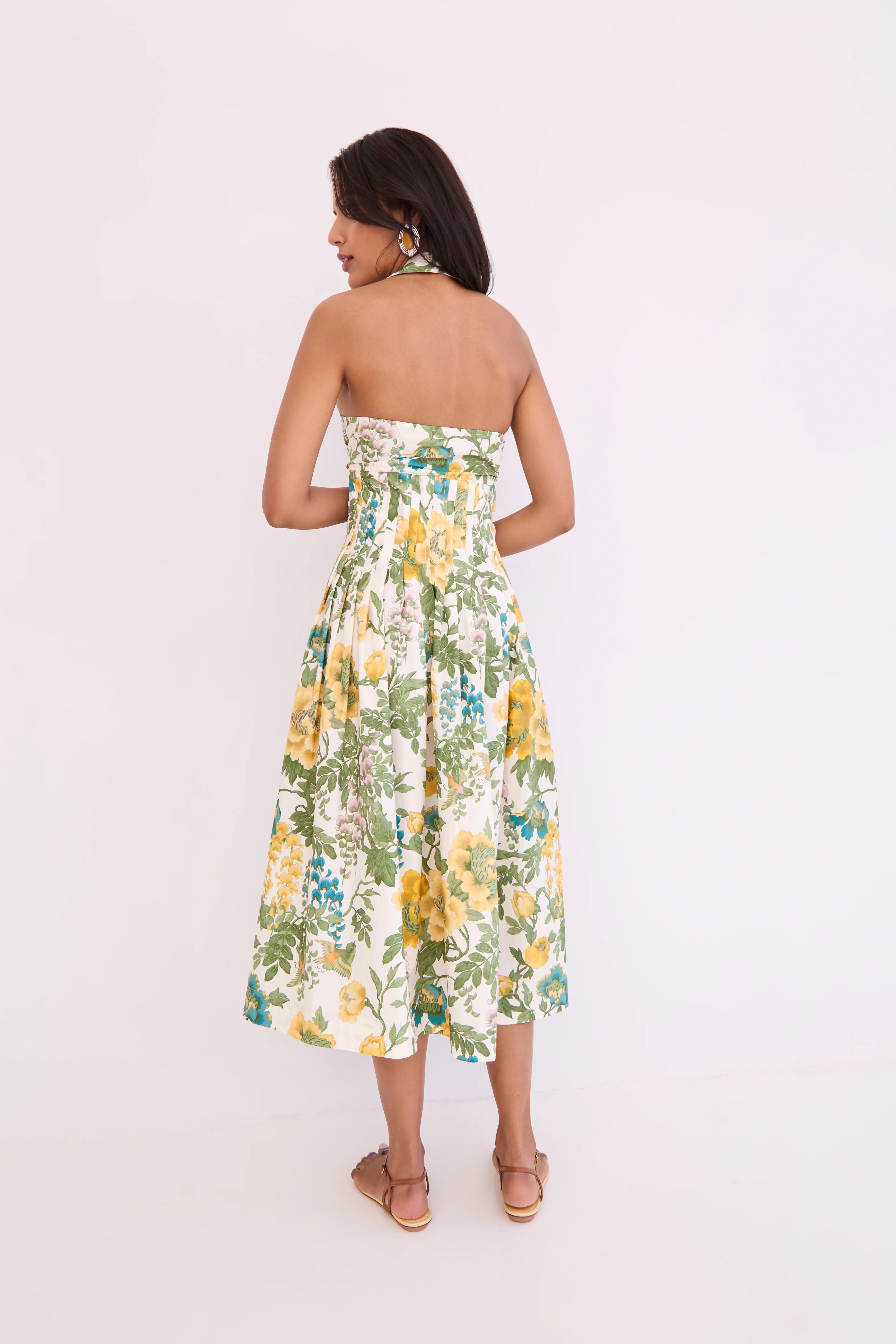 Woman wearing a strapless floral dress on a white background
