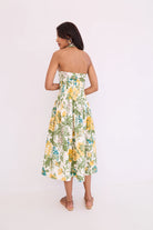 Woman wearing a strapless floral dress on a white background