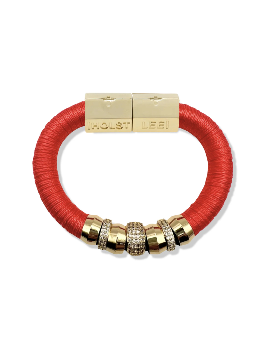 Red bracelet with gold beads and clasp on a white background
