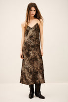 Woman wearing a patterned slip dress on a plain background