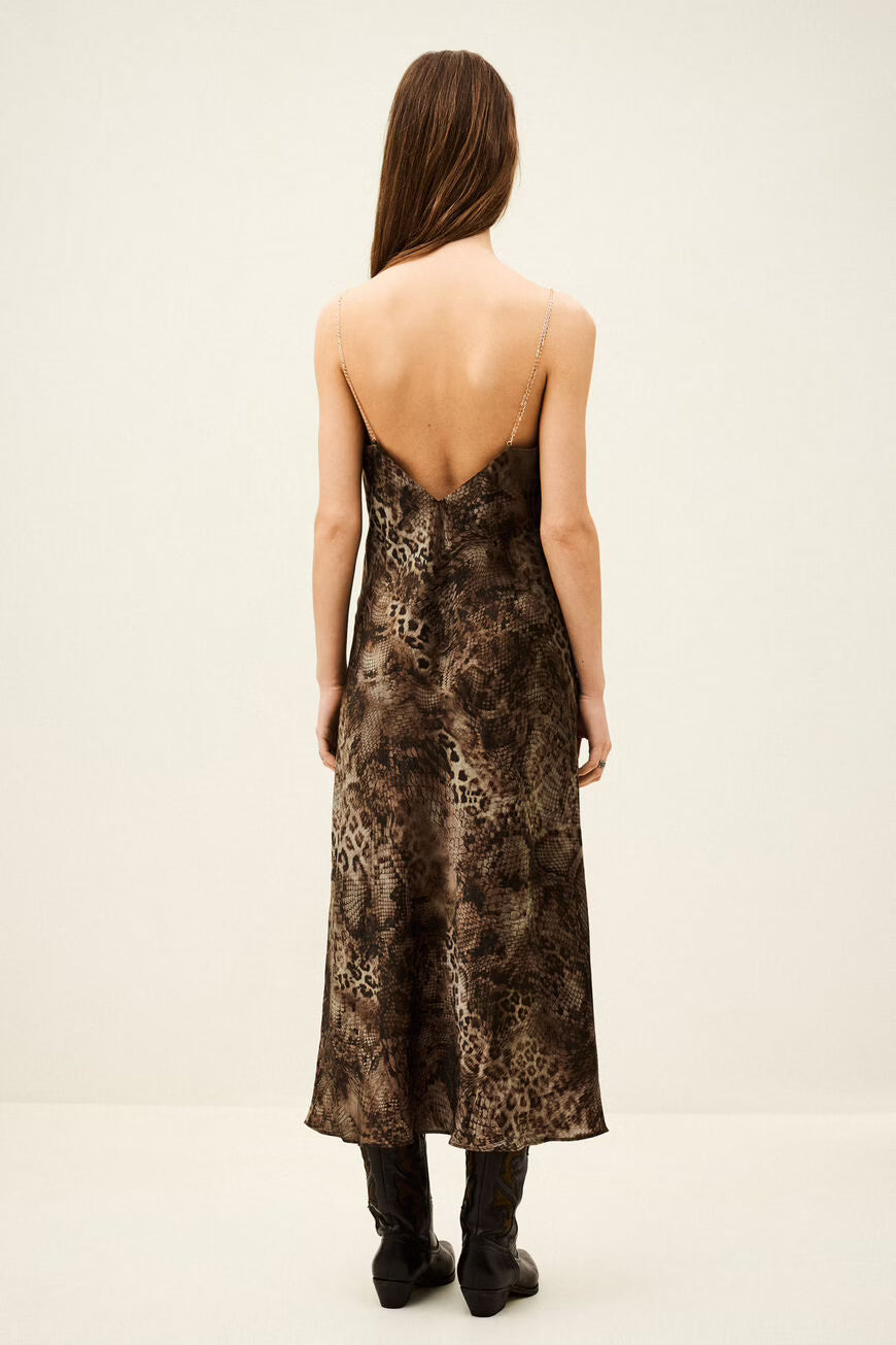 Woman wearing a patterned dress on a plain background