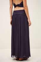 Long dark purple dress with open back on a plain background