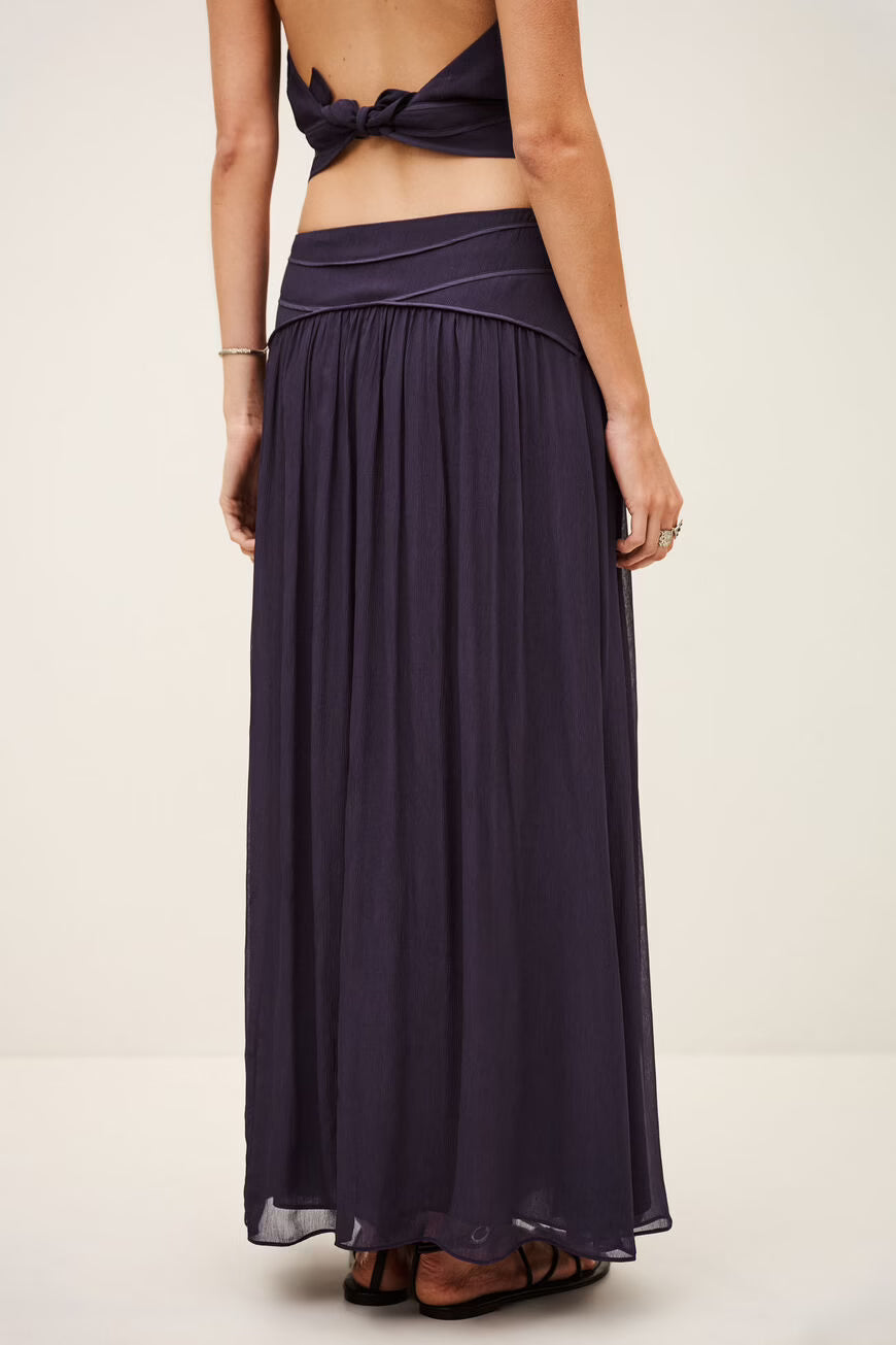Long dark purple dress with open back on a plain background
