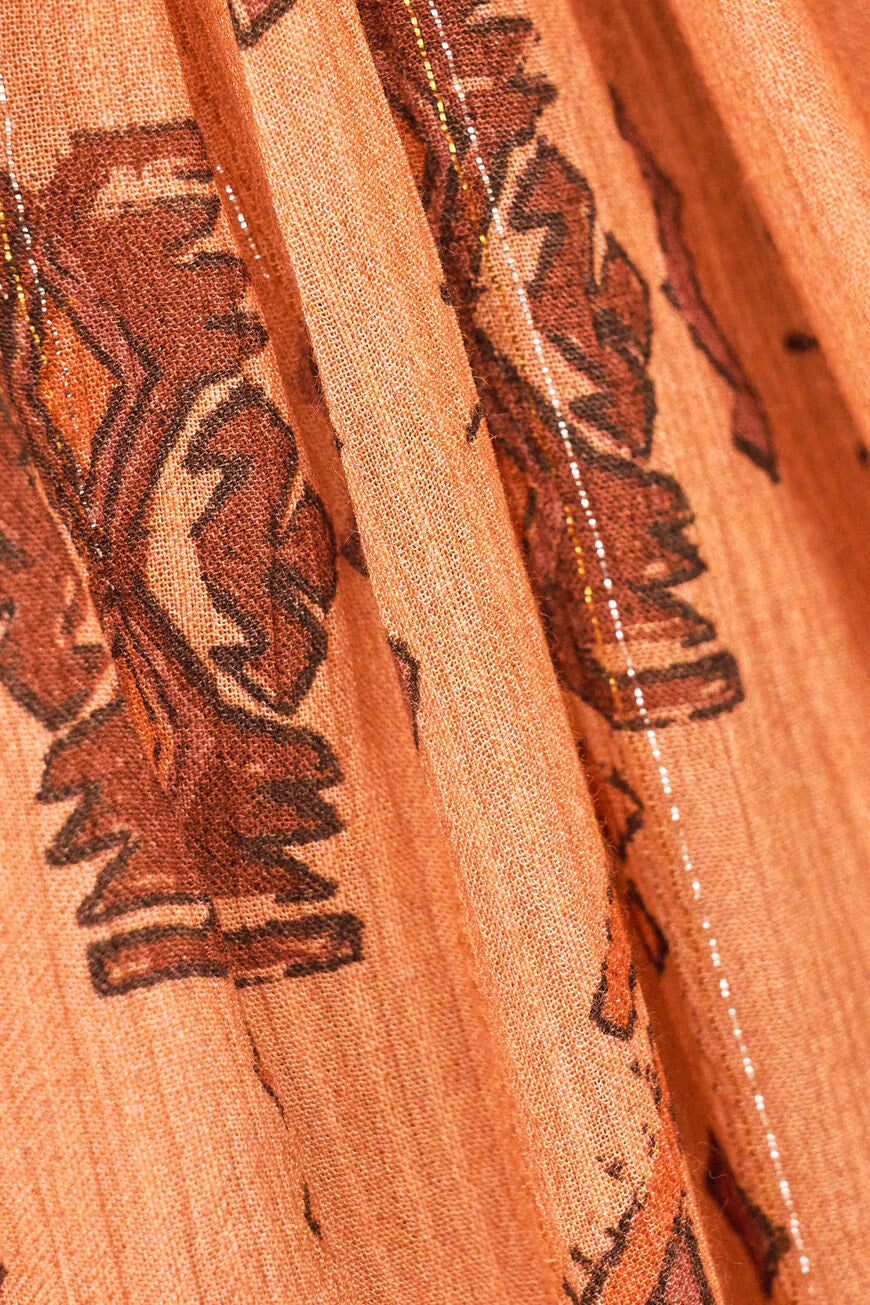 Close-up of orange fabric with black floral patterns