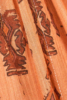 Close-up of orange fabric with black floral patterns