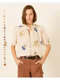 Person wearing a colorful floral shirt with a plain background