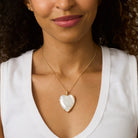 Woman wearing a gold necklace with a heart-shaped pendant
