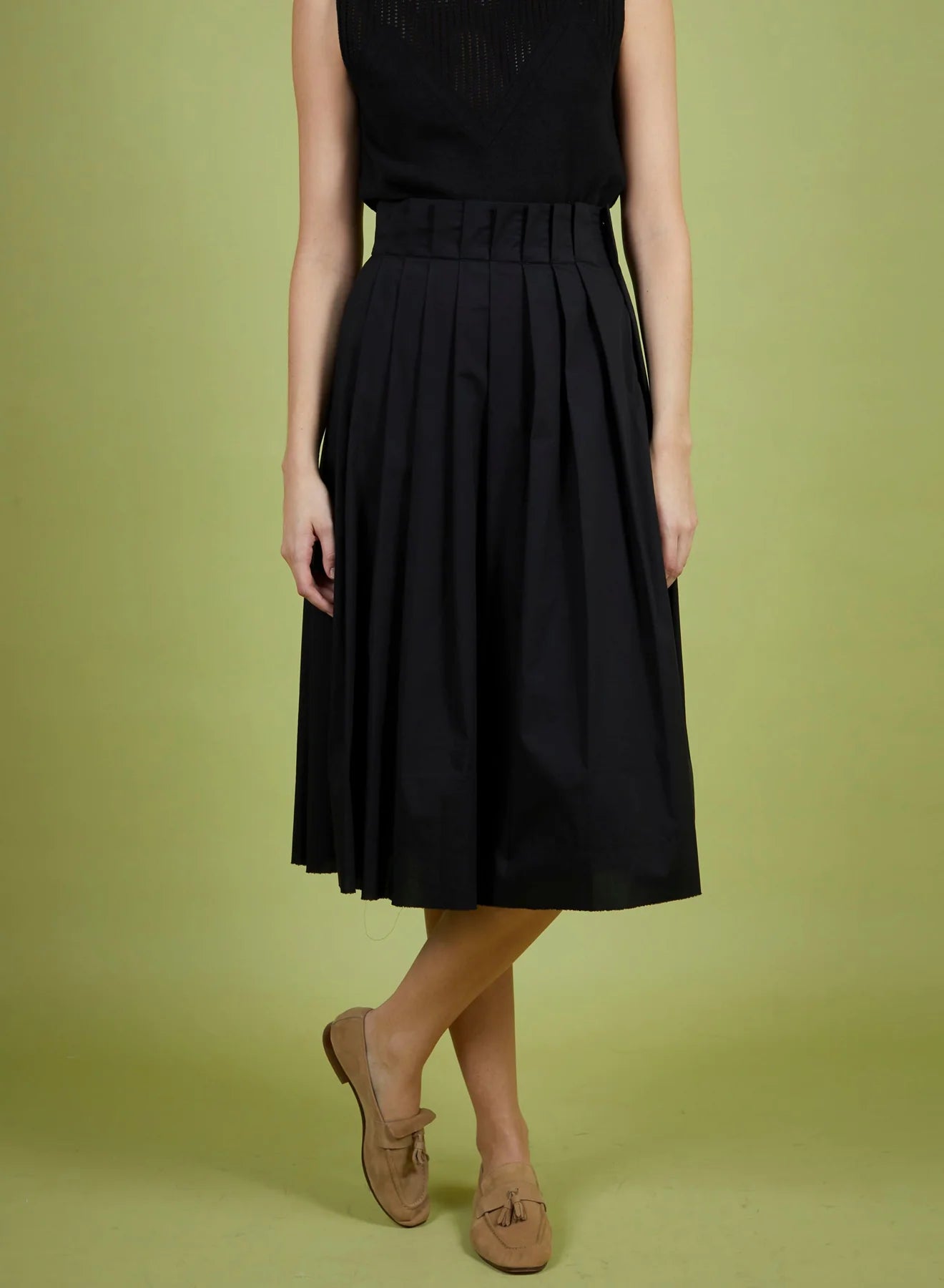 Person wearing a black dress with a green background