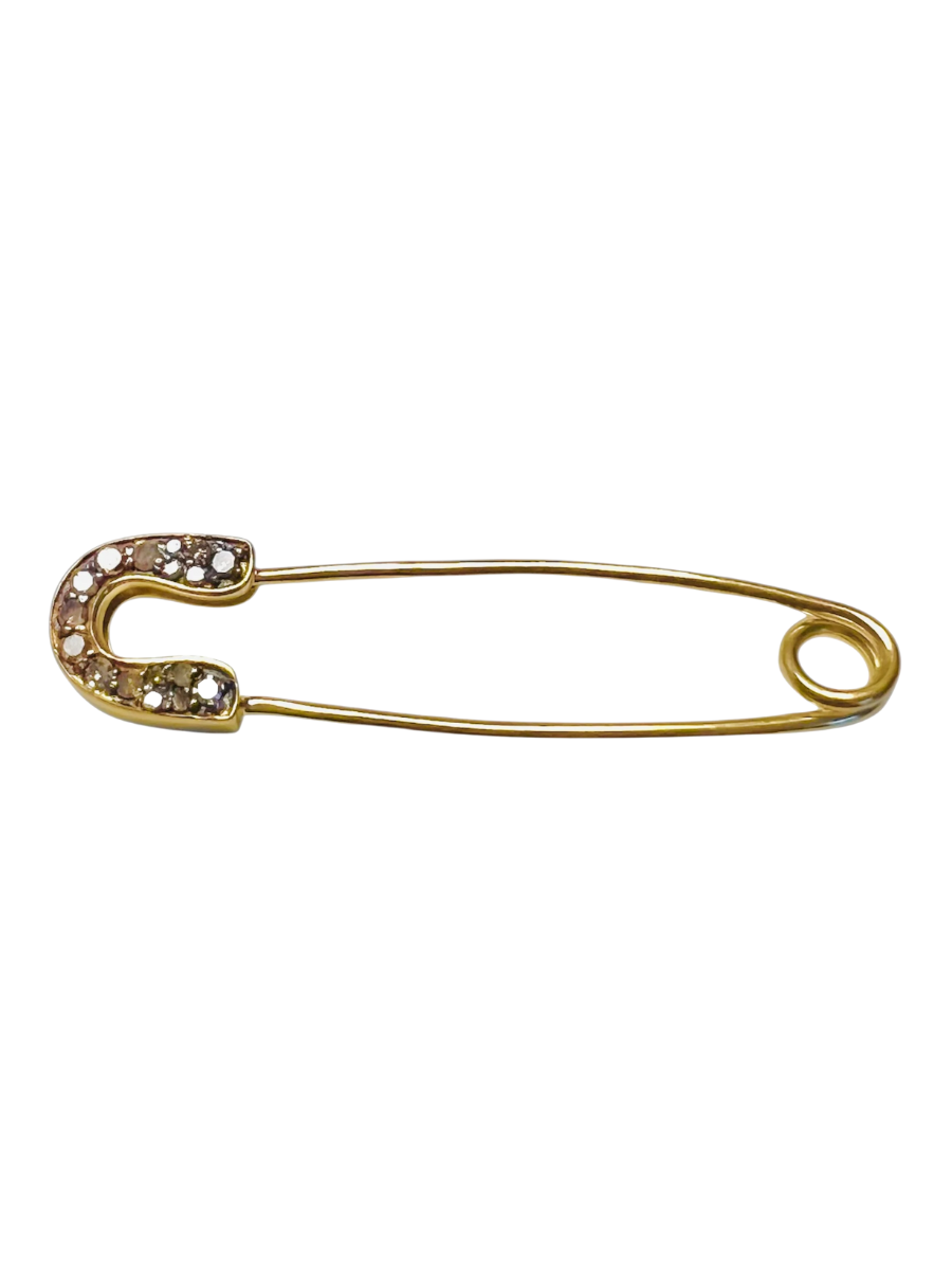 Gold safety pin with embedded stones on a white background