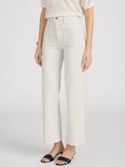 Person wearing white pinstripe pants on a light gray background