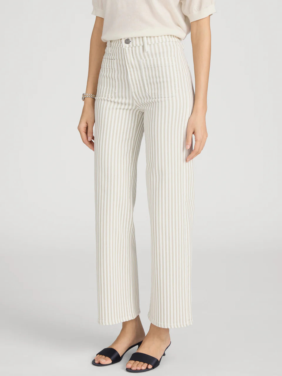 Person wearing white pinstripe pants on a light gray background