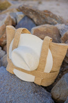 Textured beige and white bag on a rocky surface