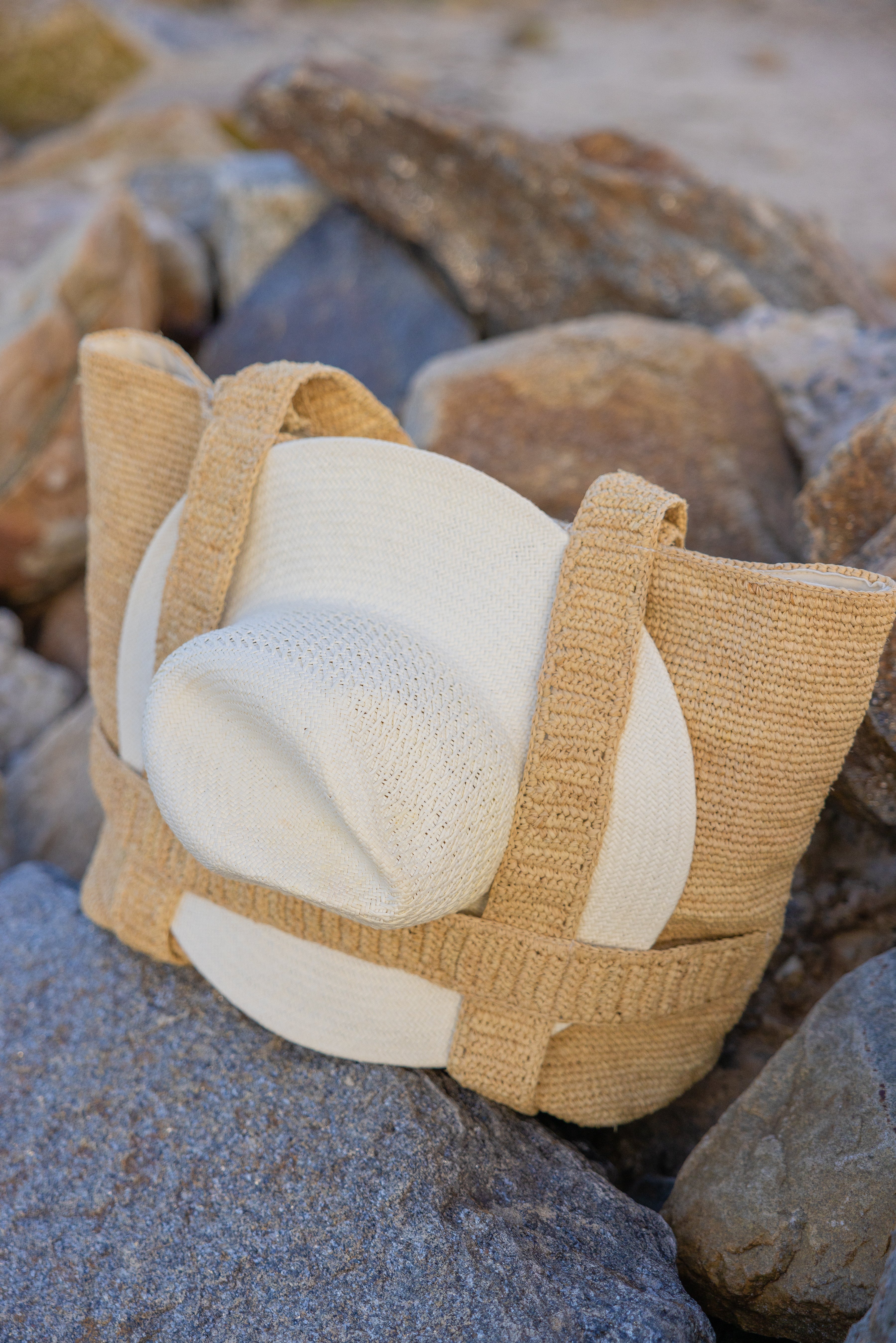 Textured beige and white bag on a rocky surface