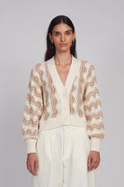 Woman wearing a patterned cardigan against a plain background