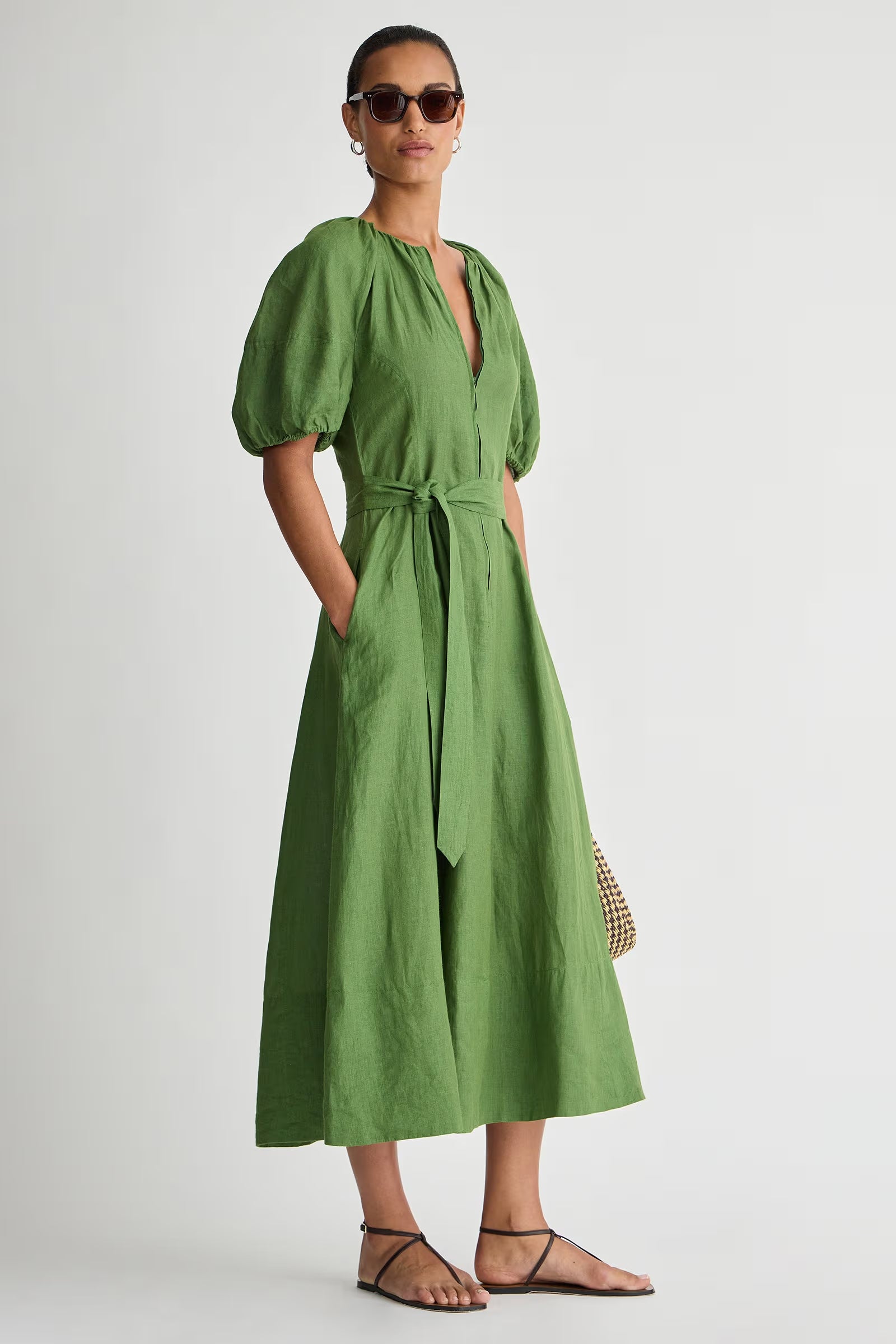 Woman wearing a green dress with puff sleeves against a white background