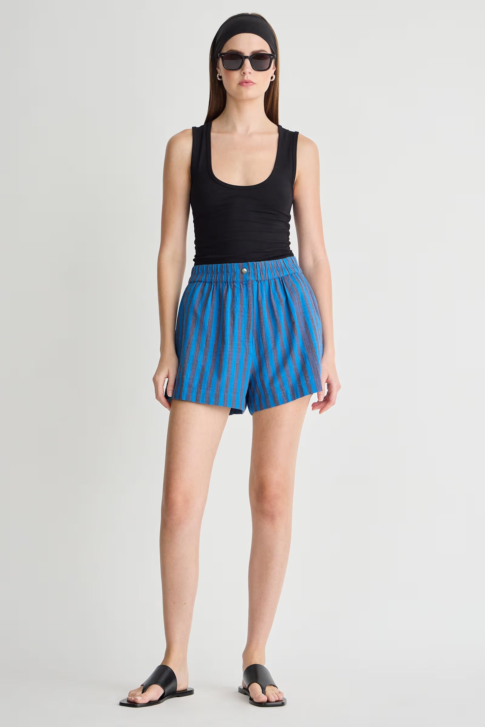 woman wearing a black tank top and blue striped shorts