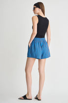 woman wearing a black tank top and blue striped shorts