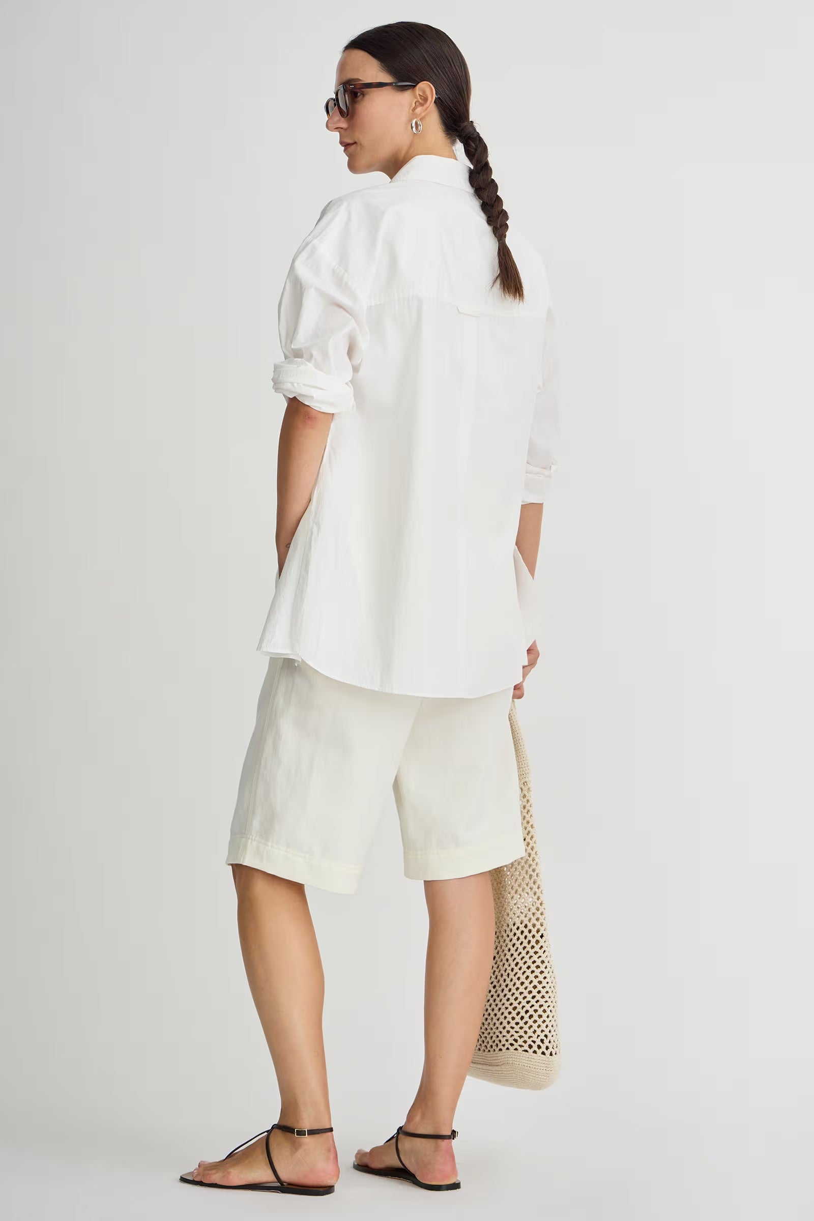 Woman wearing a white outfit with a plain background
