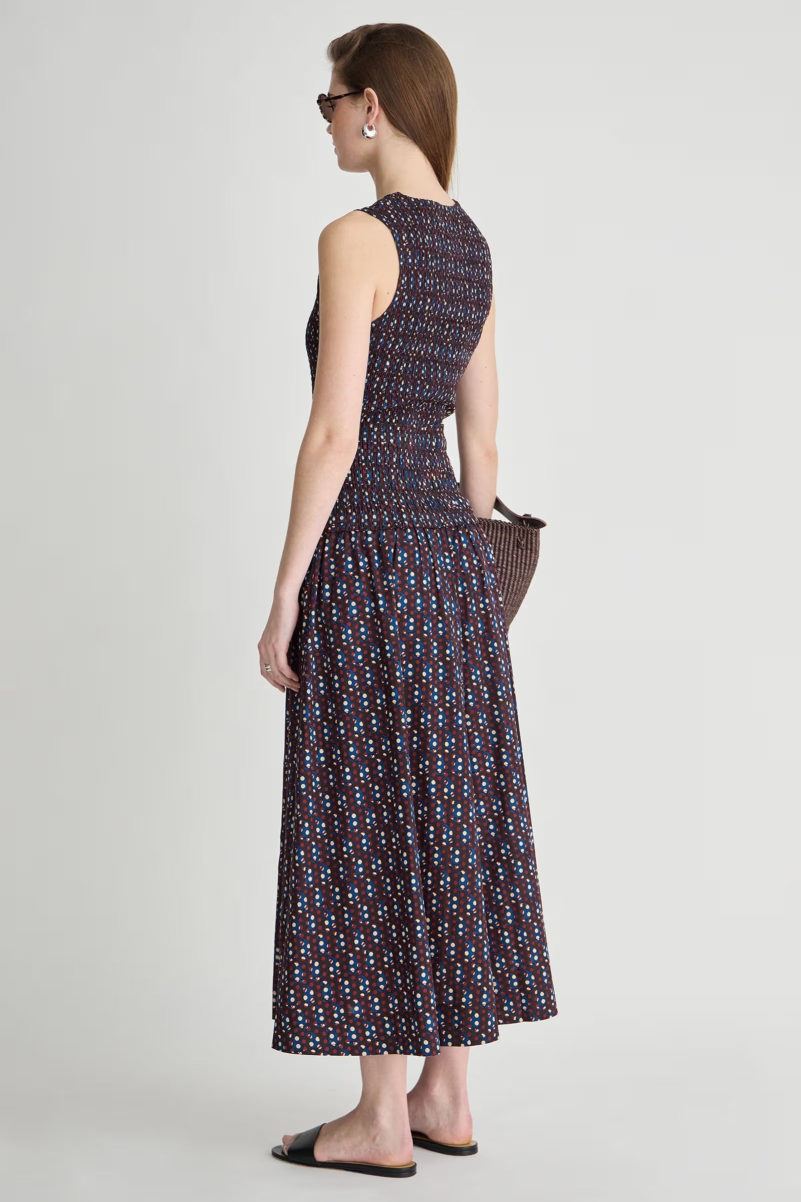 Woman wearing a patterned dress on a plain background