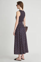 Woman wearing a patterned dress on a plain background
