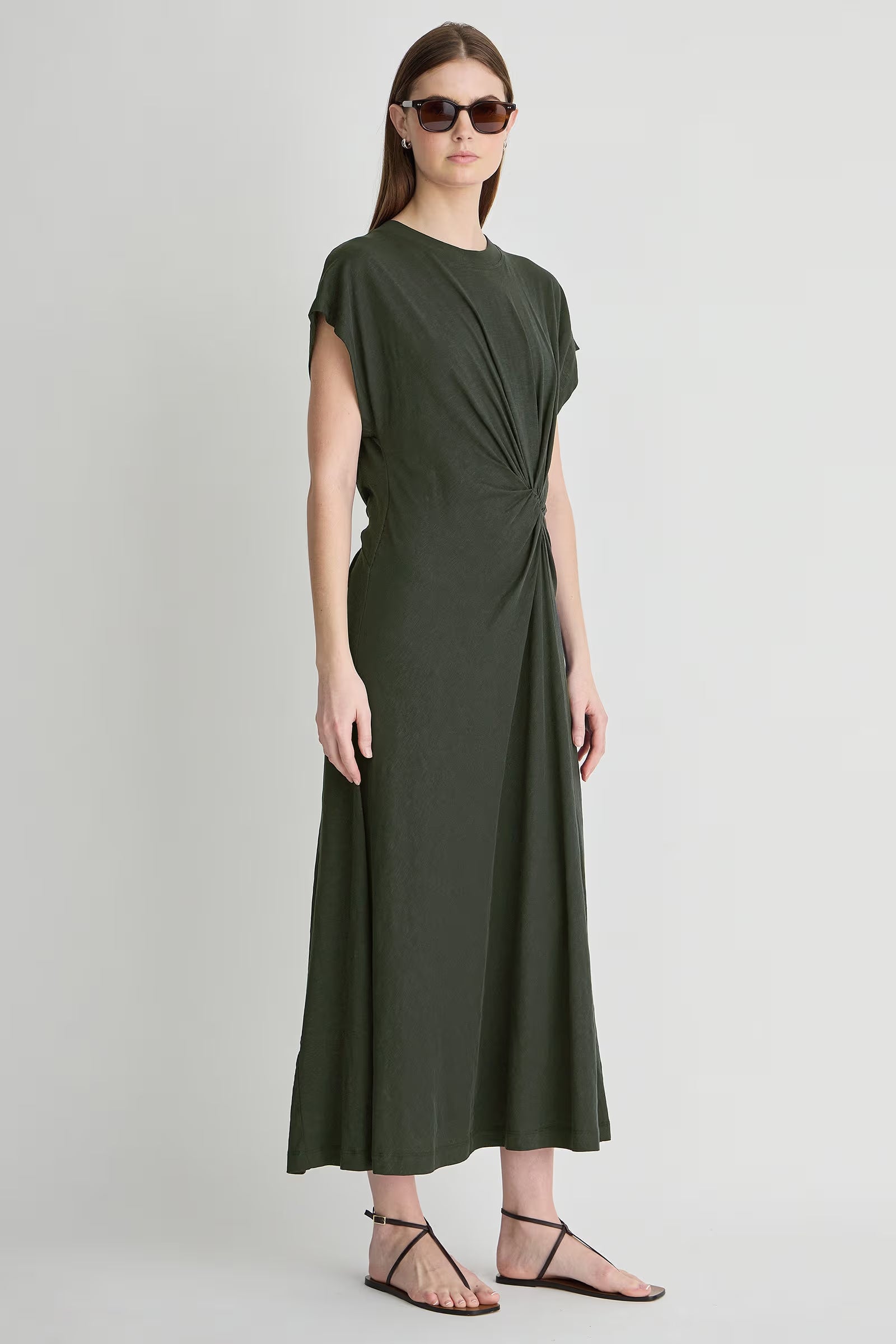 Woman wearing a green dress on a light gray background