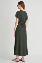 Woman wearing a green dress with a knot detail on a white background