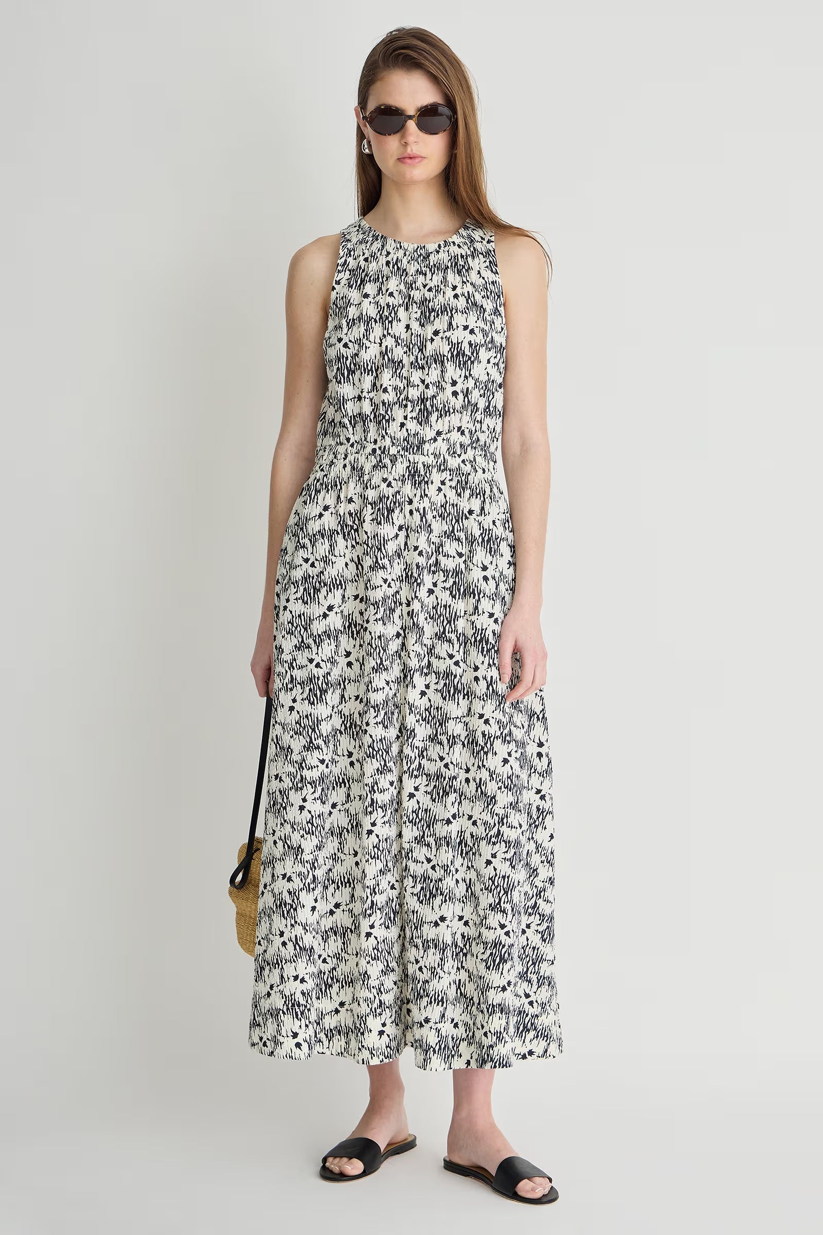 Woman wearing a sleeveless floral dress on a white background