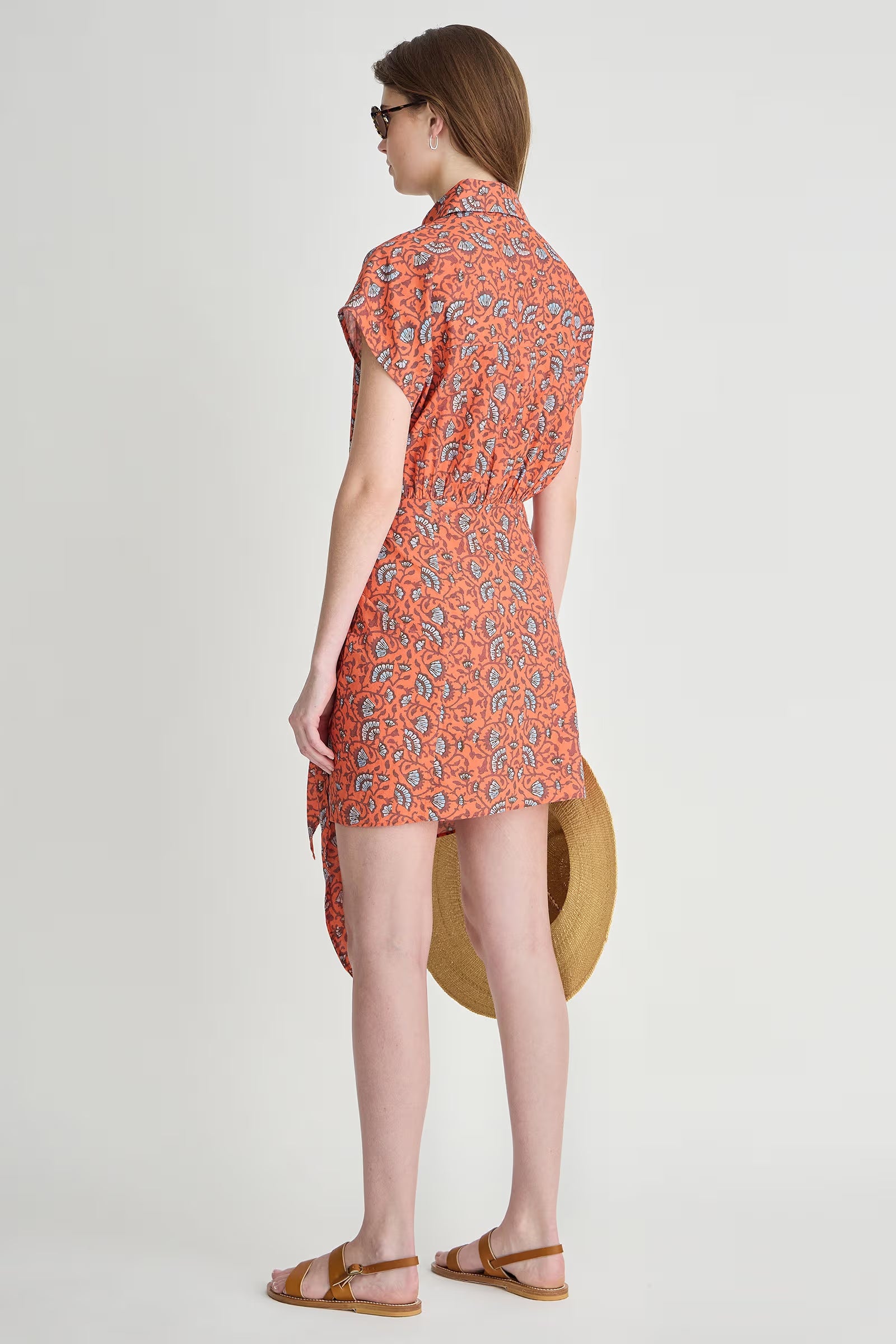Woman wearing a red patterned dress on a white background