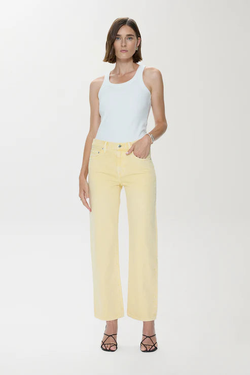 Woman wearing a white sleeveless top and yellow pants on a white background