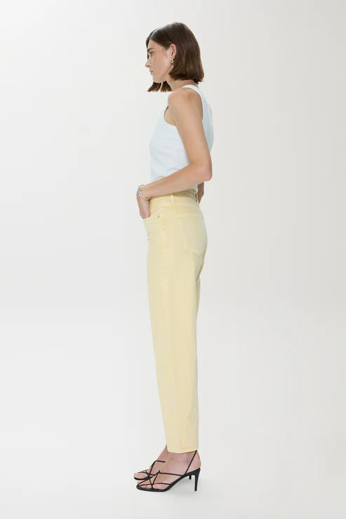 Woman wearing a light blue top and yellow pants on a white background