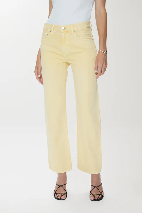 Person wearing light yellow jeans on a white background