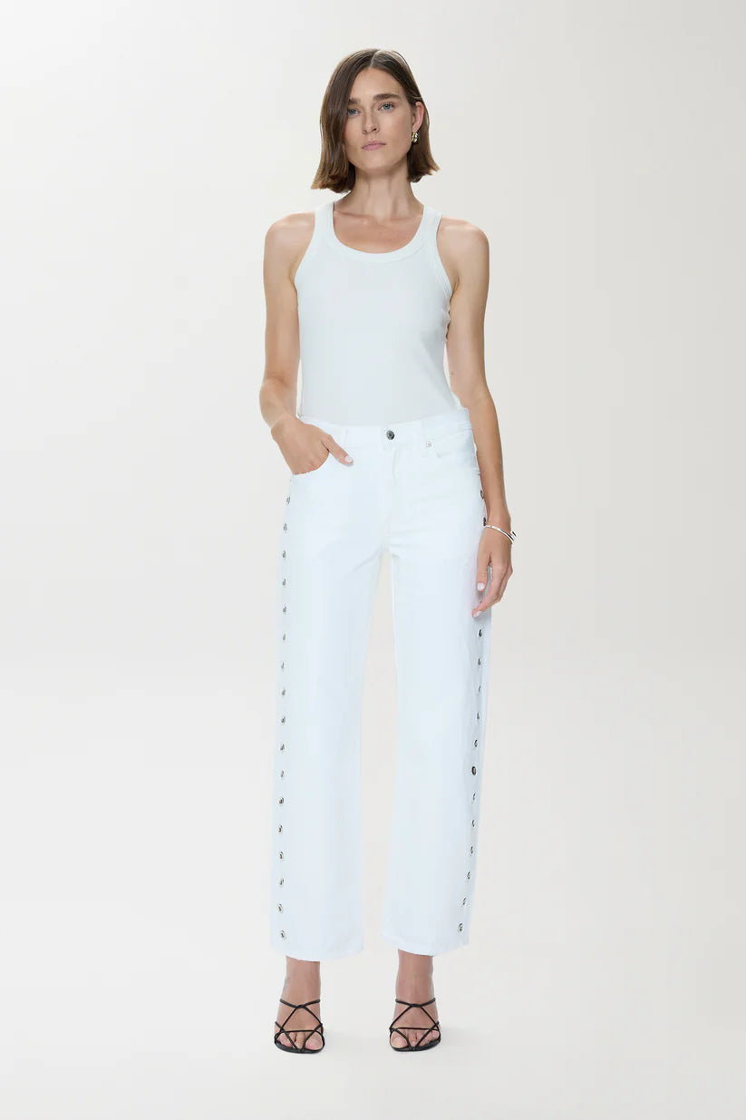Woman wearing a white sleeveless top and light blue jeans on a white background