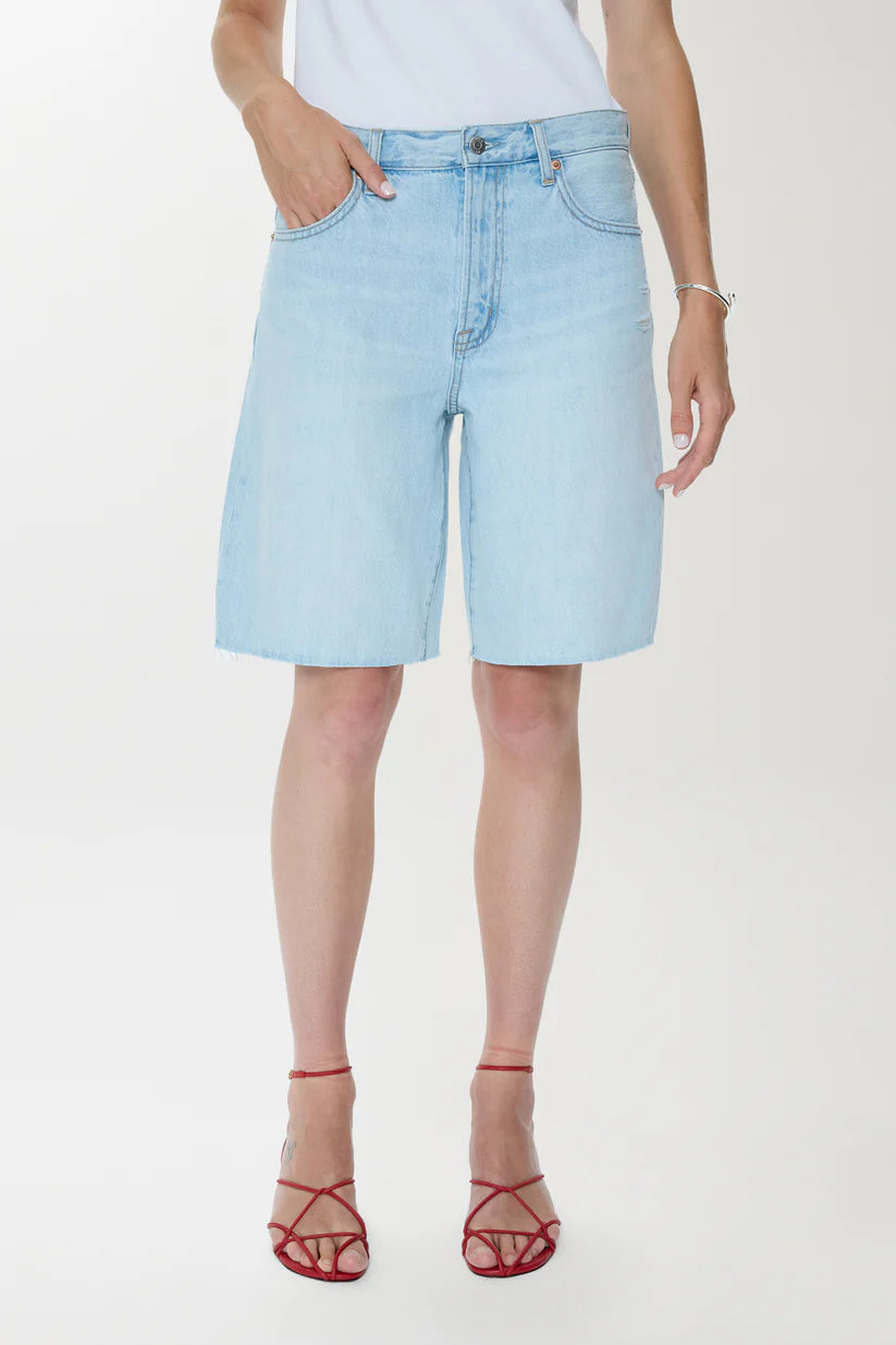 Light blue denim shorts worn by a person on a white background