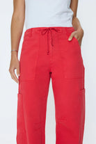 Red cargo pants worn by a person on a white background