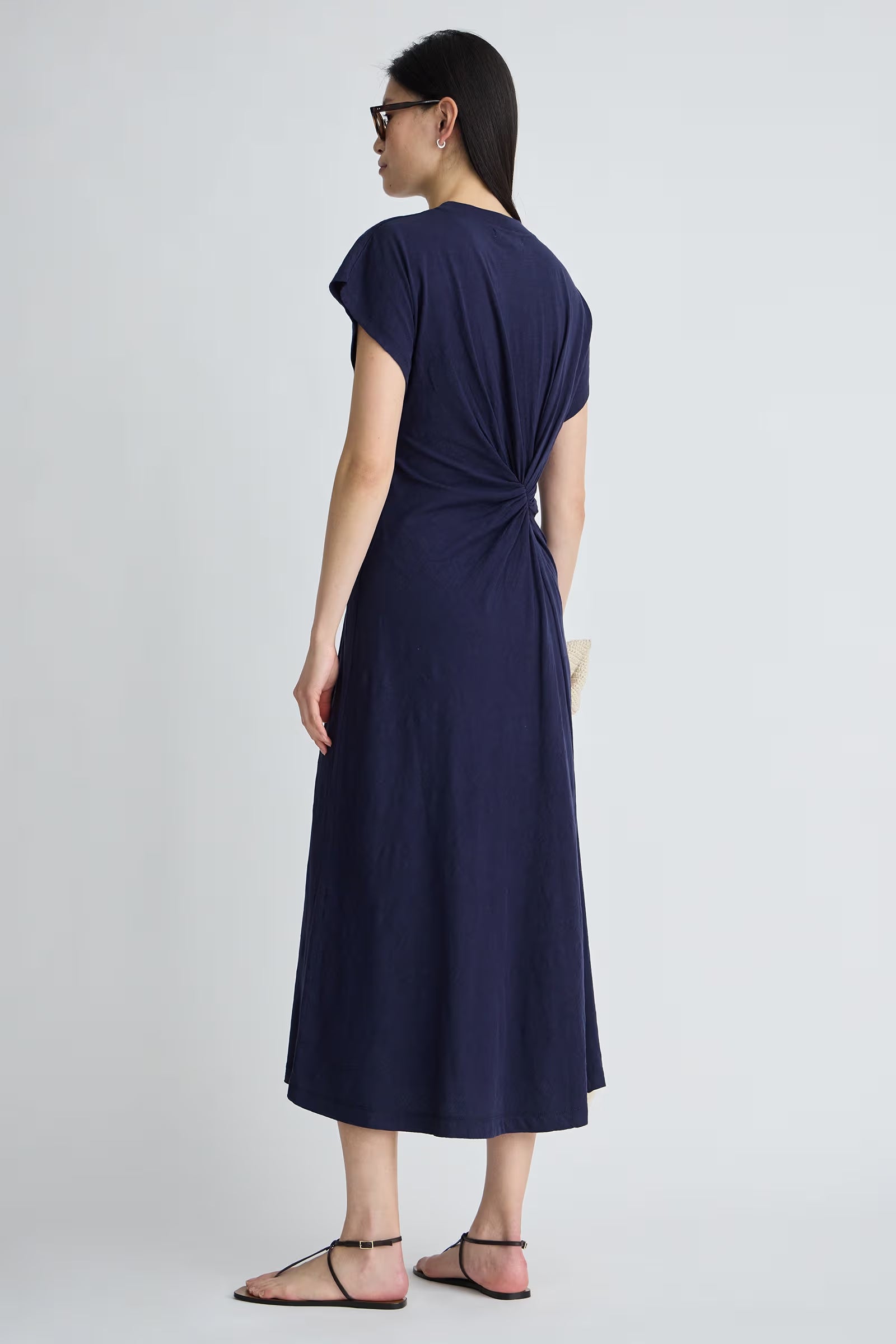 Woman wearing a navy blue dress on a white background