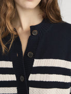 Navy and white striped cardigan with button details on a plain background