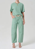 Person wearing a mint green t-shirt and cargo pants on a white background