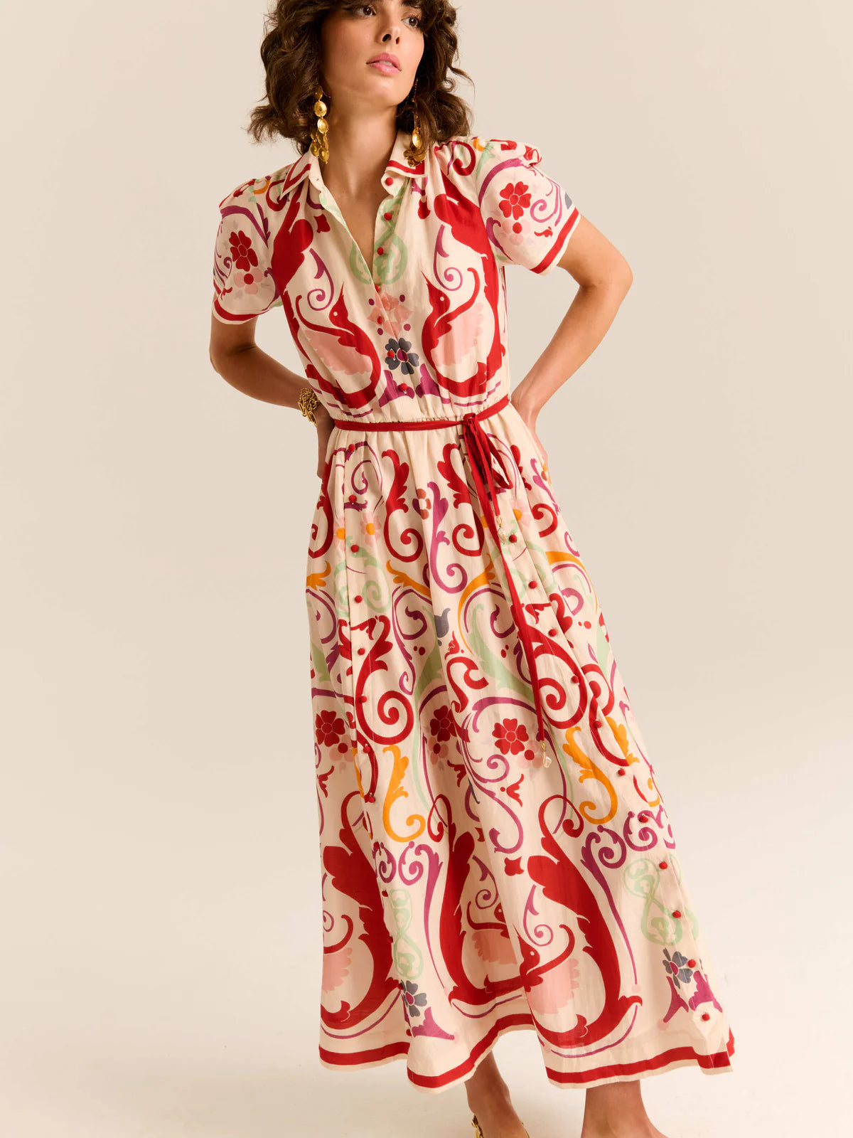 Woman wearing a red and white patterned dress on a beige background