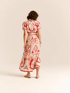 Woman wearing a patterned dress on a plain background