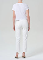 Person wearing a white t-shirt and pants on a plain background