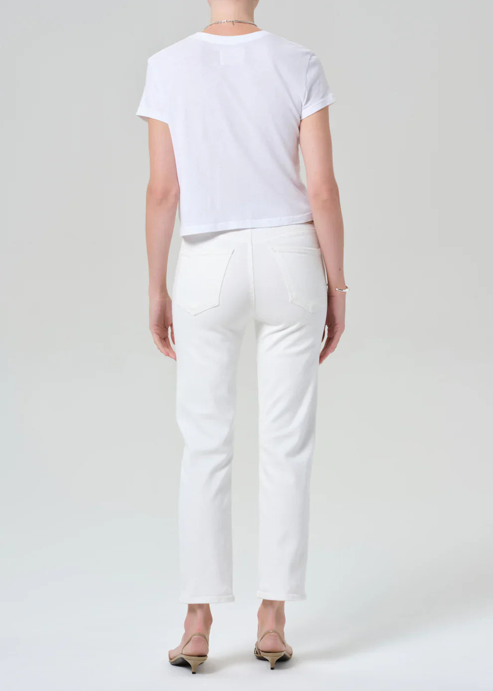 Person wearing a white t-shirt and pants on a plain background